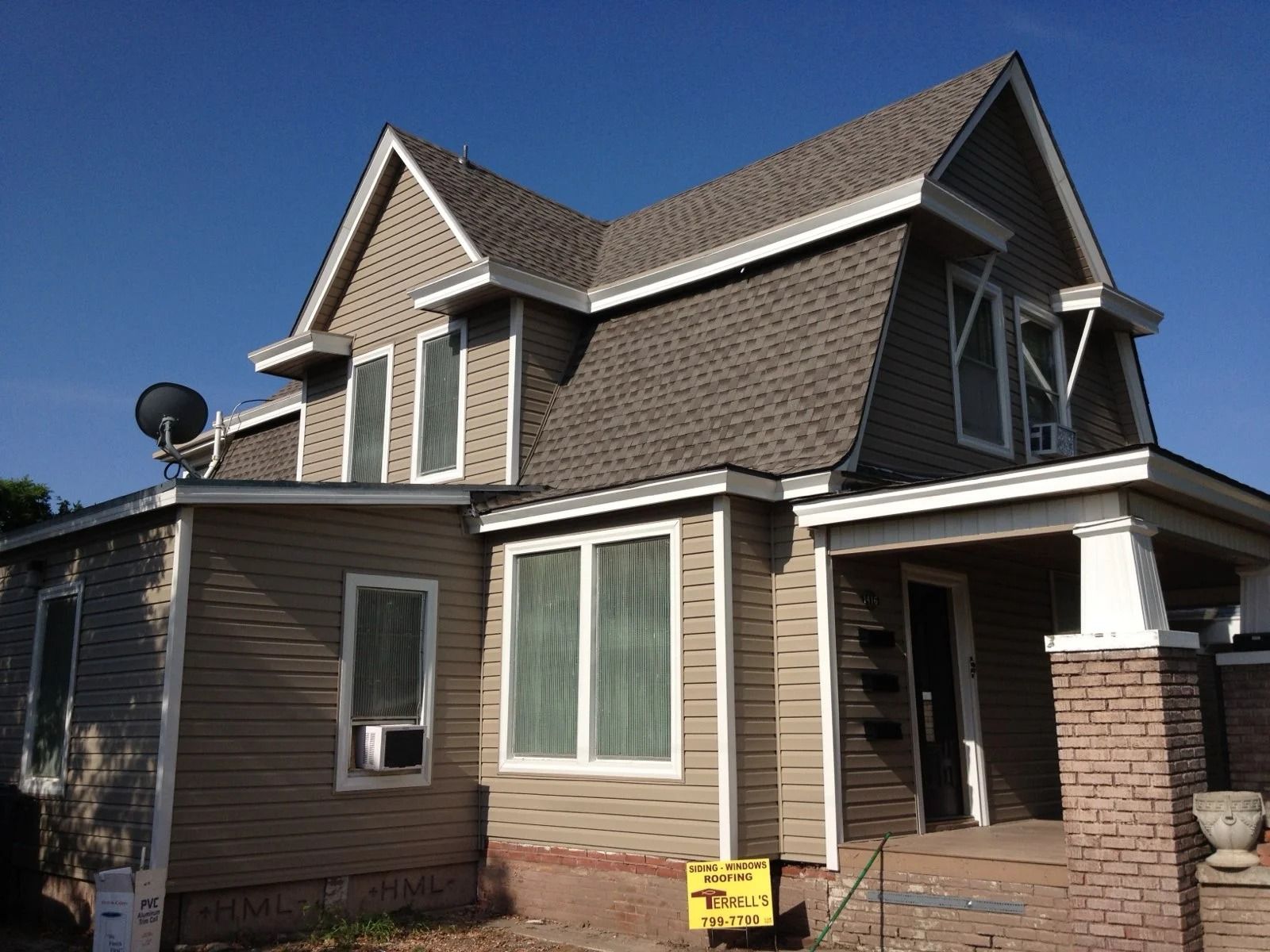 Same home finished with new tan siding and white windows