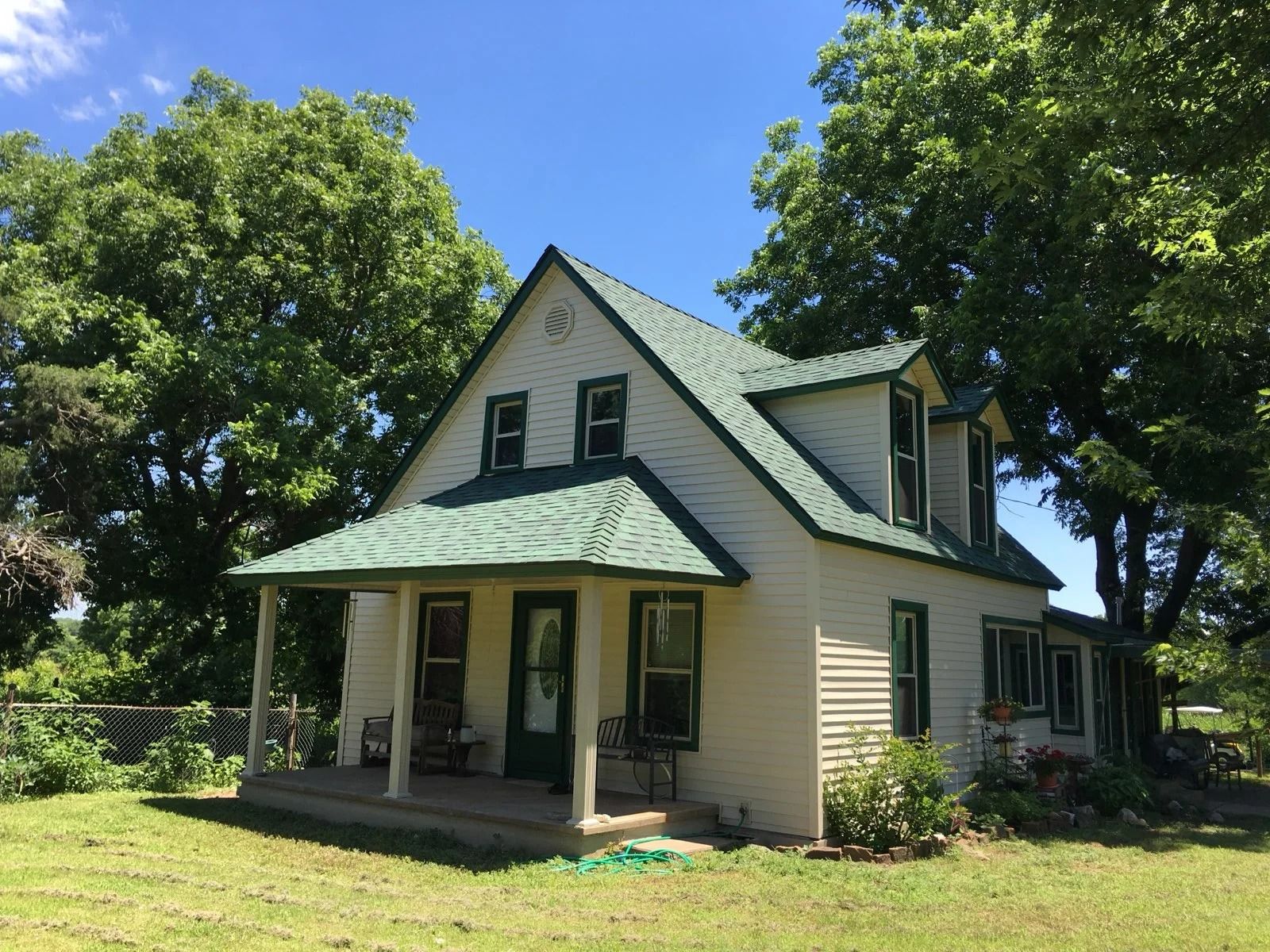 Same home with new cream siding and green roof trim