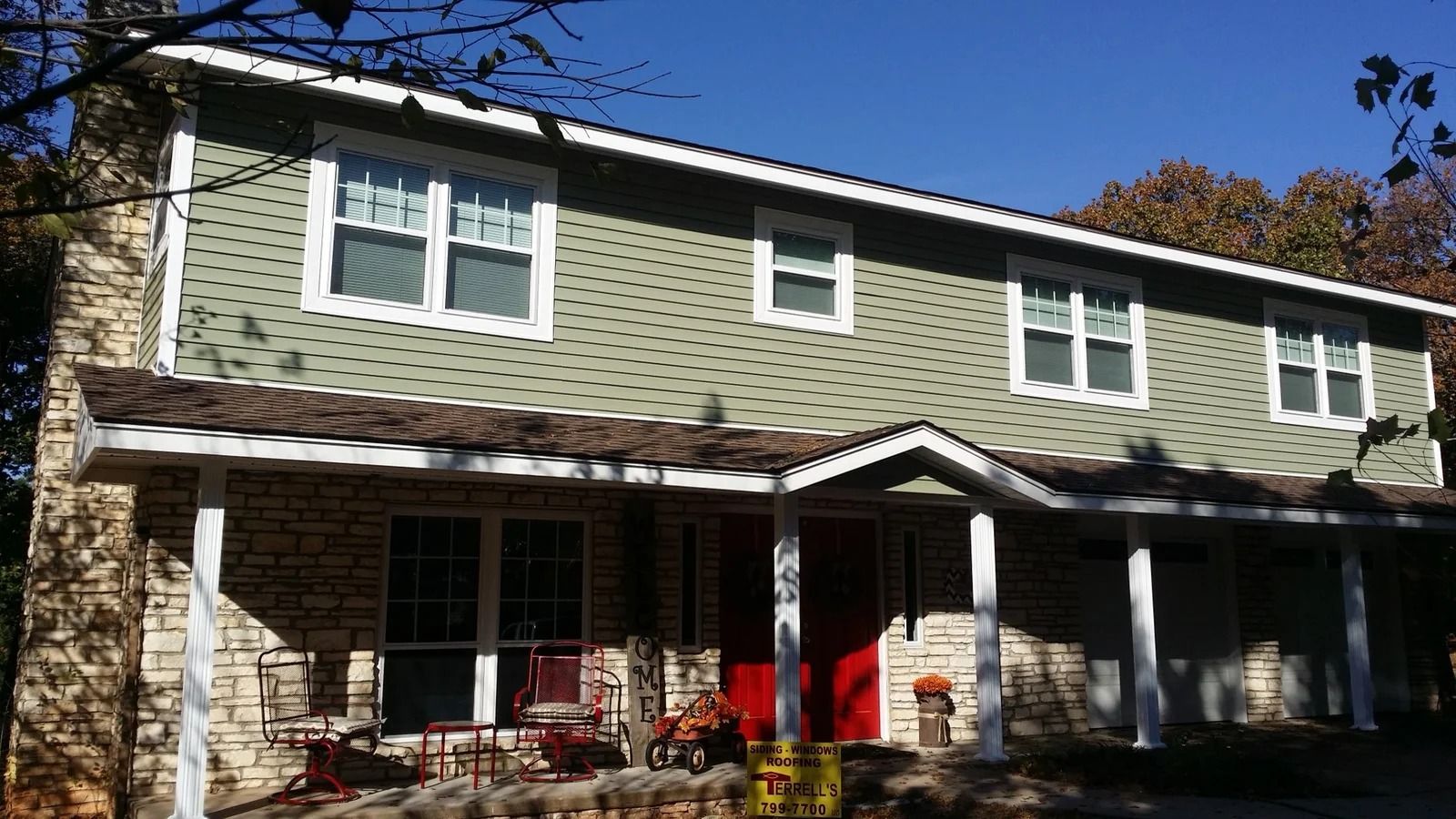 Same home with new sage green siding and white windows